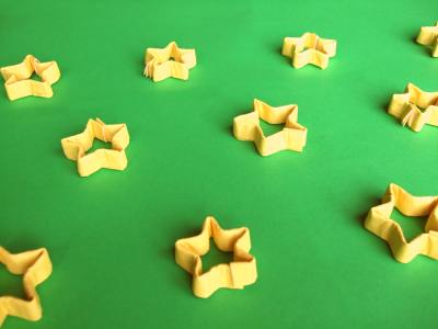 lots of origami christmas stars on a table