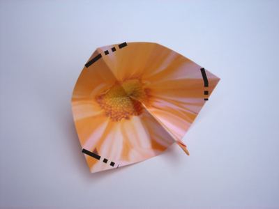 folding an orange origami flower
