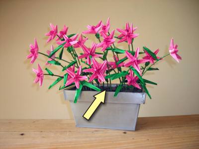 zandkorrels van papier in een potje met origami bloemen