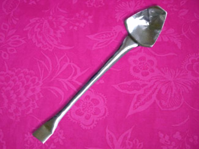 Origami silver spoon on a pink tablecloth