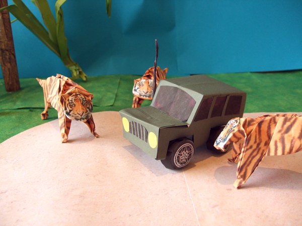 origami tigers standing around a jeep
