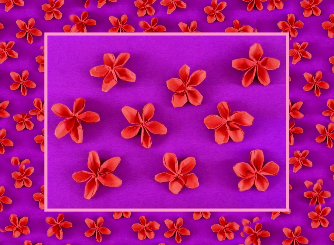 Card with red origami flowers on a purple background