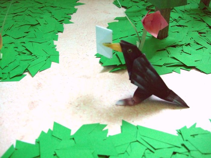 origami bird walking about through the forest