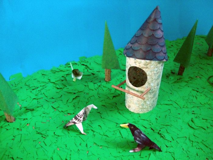 origami birds next to a paper birdhouse