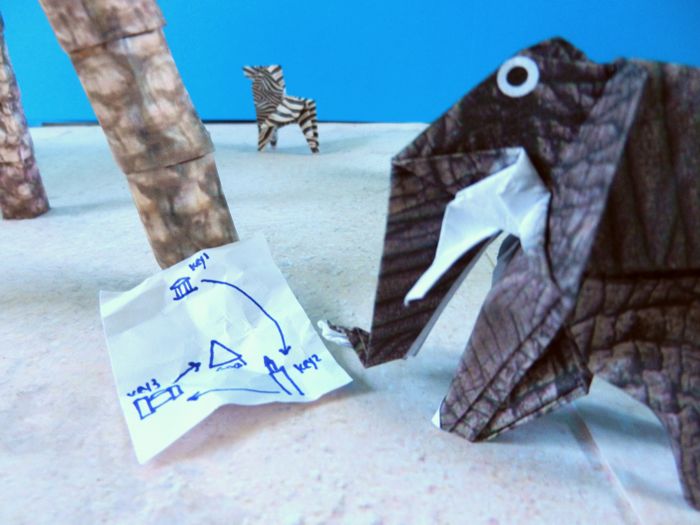 origami elephant looking at a treasure map