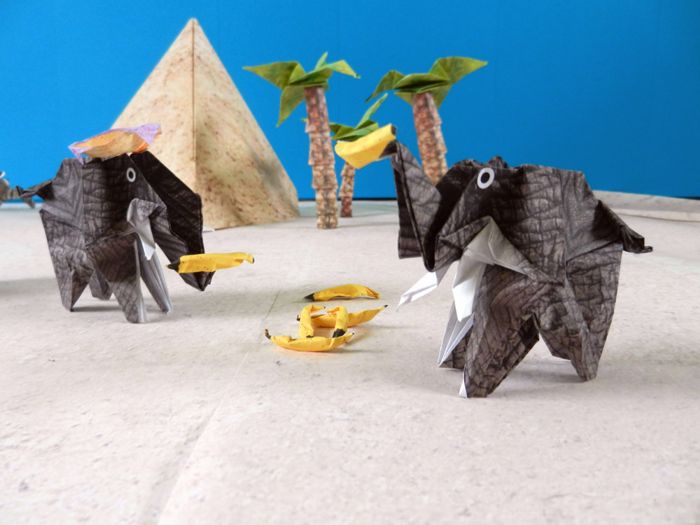 two funny origami elephants eating some bananas