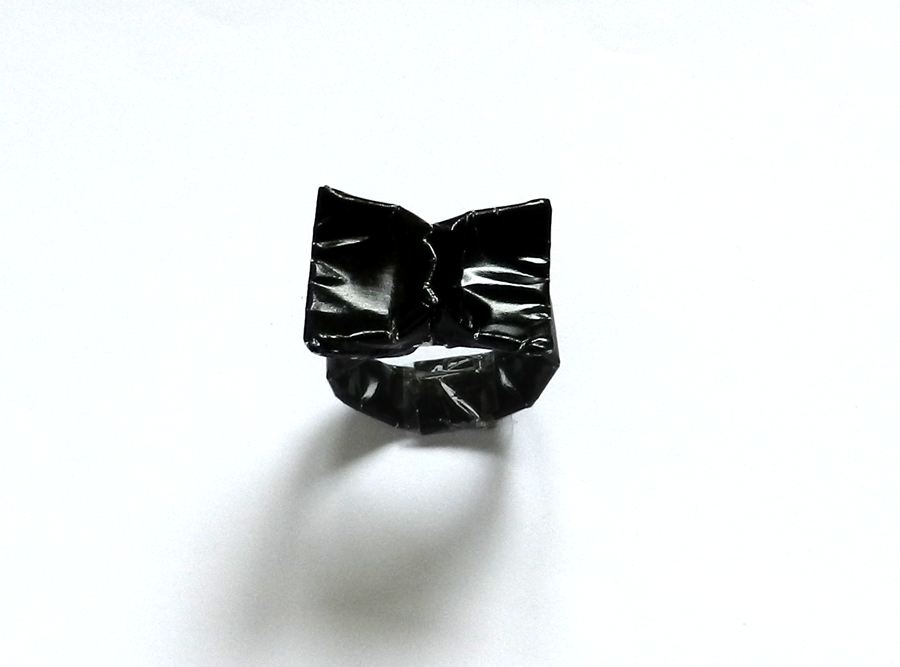 glimmende zwarte ring met strikje van papier