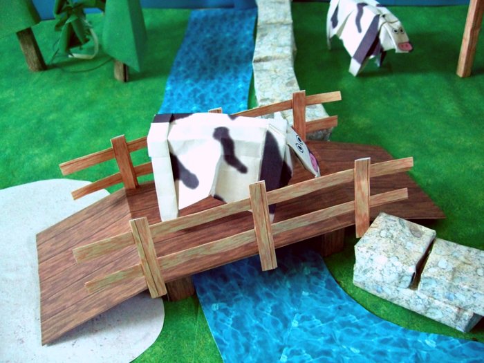 origami cow on a kirigami bridge