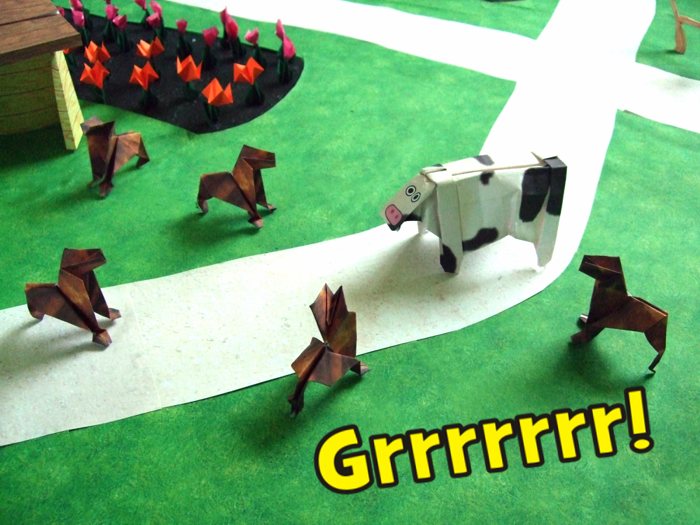 origami dogs looking at a cow