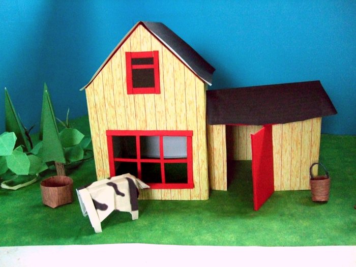 cow looking through the window of a paper house