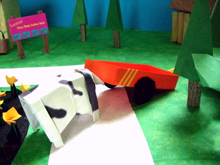 cow pushing a kirigami wagon