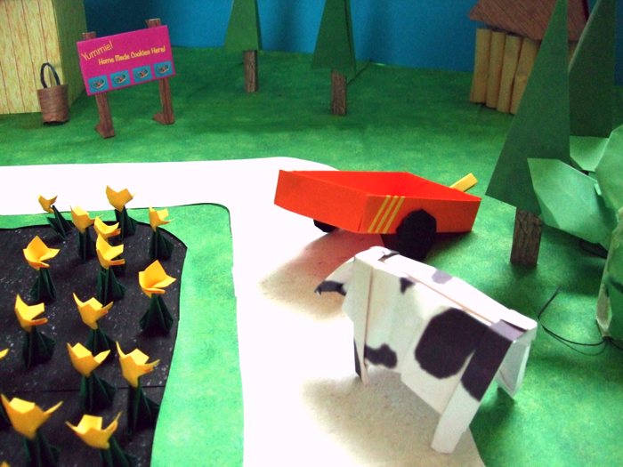 funny cow looking at a kirigami wagon