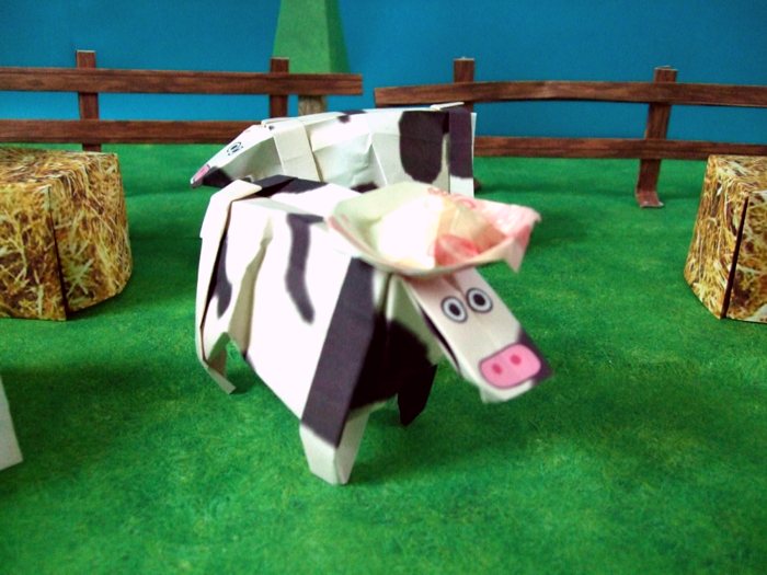 cow with an origami hat on her head