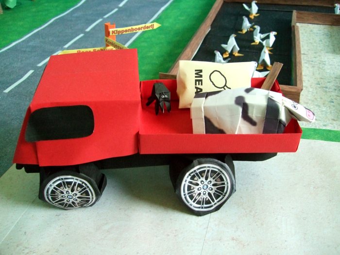 cow lying on a kirigami pick up truck