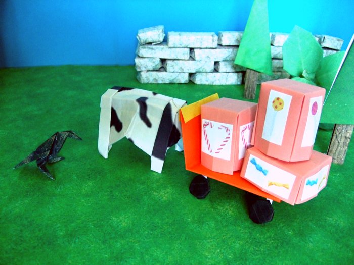 cow pushing a kirigami wagon packed with candy boxes