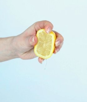 stuk fruit dat in iemands hand wordt geperst