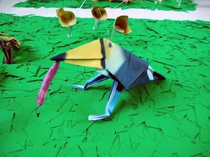 funny origami bird with a large worm in his mouth