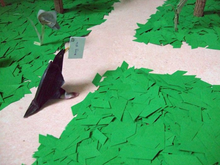 origami bird walking about in the forest