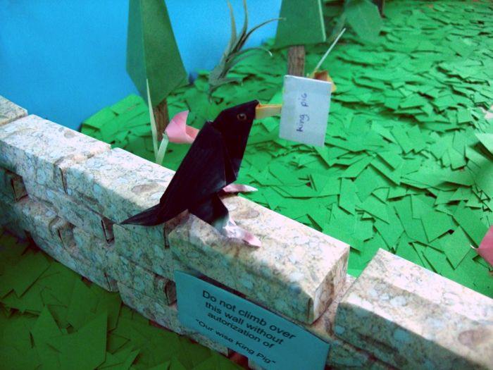 bird standing on an origami wall