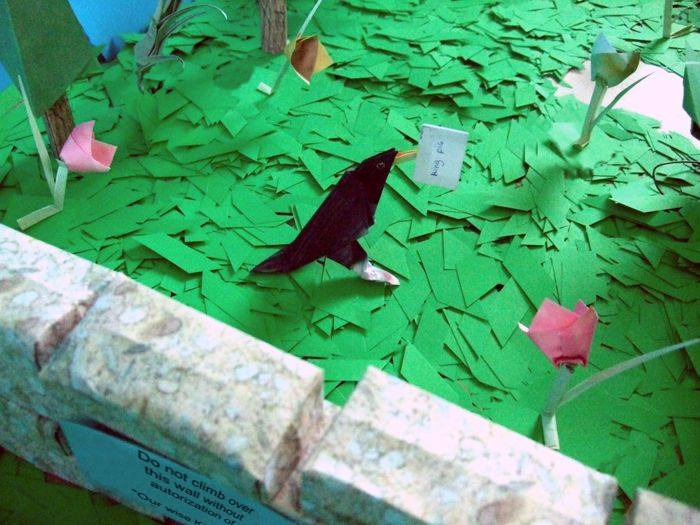 bird climbing over an origami wall