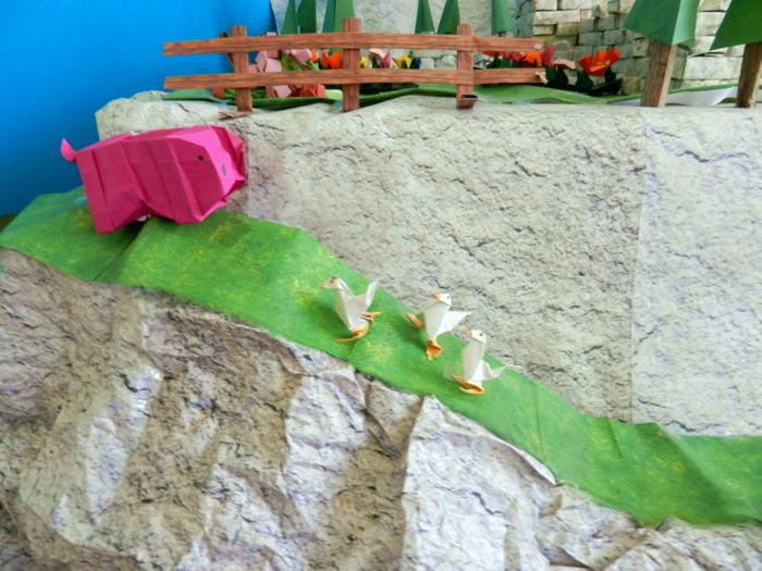 origami chickens and a pig on a mountain path