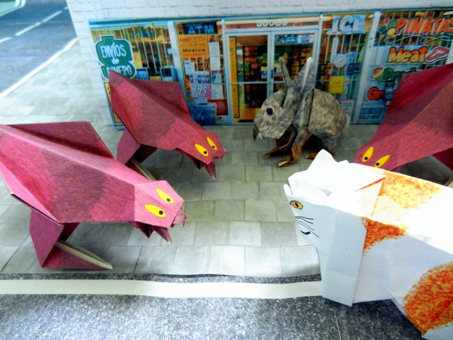 origami monsters threatening a cat and rabbit