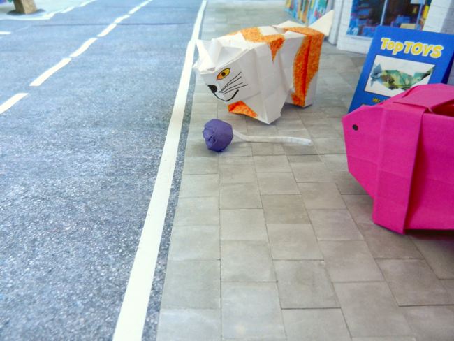 origami pig and cat looking at a smoke bomb