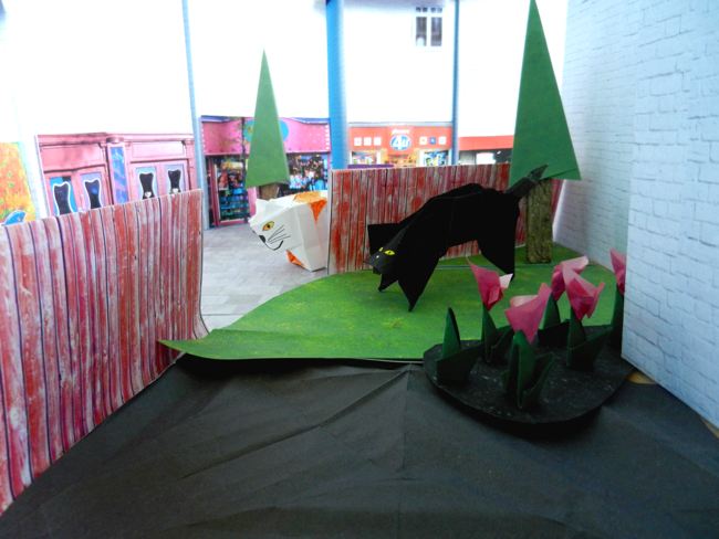 origami black cat in a papercraft backyard