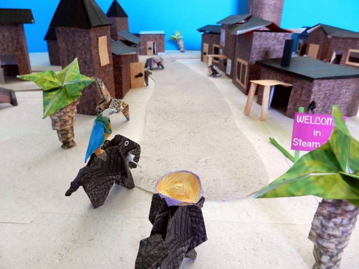 origami animals walking through a large kirigami city