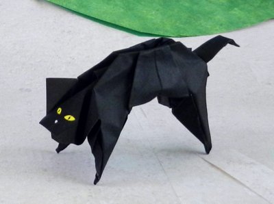 Black origami cat with bright eyes